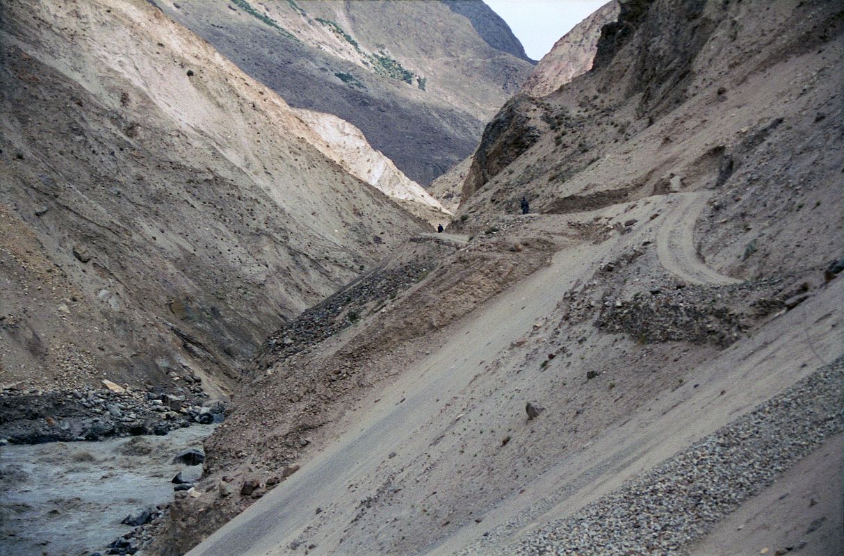 08 Road Though Braldu Gorge To Askole Slants Dangerously Towards The Roaring Braldu River On our seven-hour 117km jeep ride from Skardu to the trailhead at Thongol (2850m), we drove through the 40km Braldu Gorge, where the road is blasted out of the rocks next to the roaring Braldu River. The sickeningly narrow gravel road sometimes slants dangerously towards the Braldu River. You have to withstand being scared constantly for two hours with your life clearly in your driver�s eyes, hands and feet. 'Oh well', I thought. The scariest thing for me was when the jeep had to do three-point turns around hairpin curves. He'd get to the edge with the foaming Braldu River hundreds of metres below, and then reverse back up the hill. 'I hope he knows the reverse gear', I think to myself.